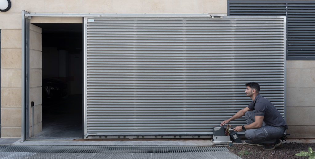 Técnico de eguzkimendi reparando y haciendo el mantenimiento de puertas automáticas en un garaje. 